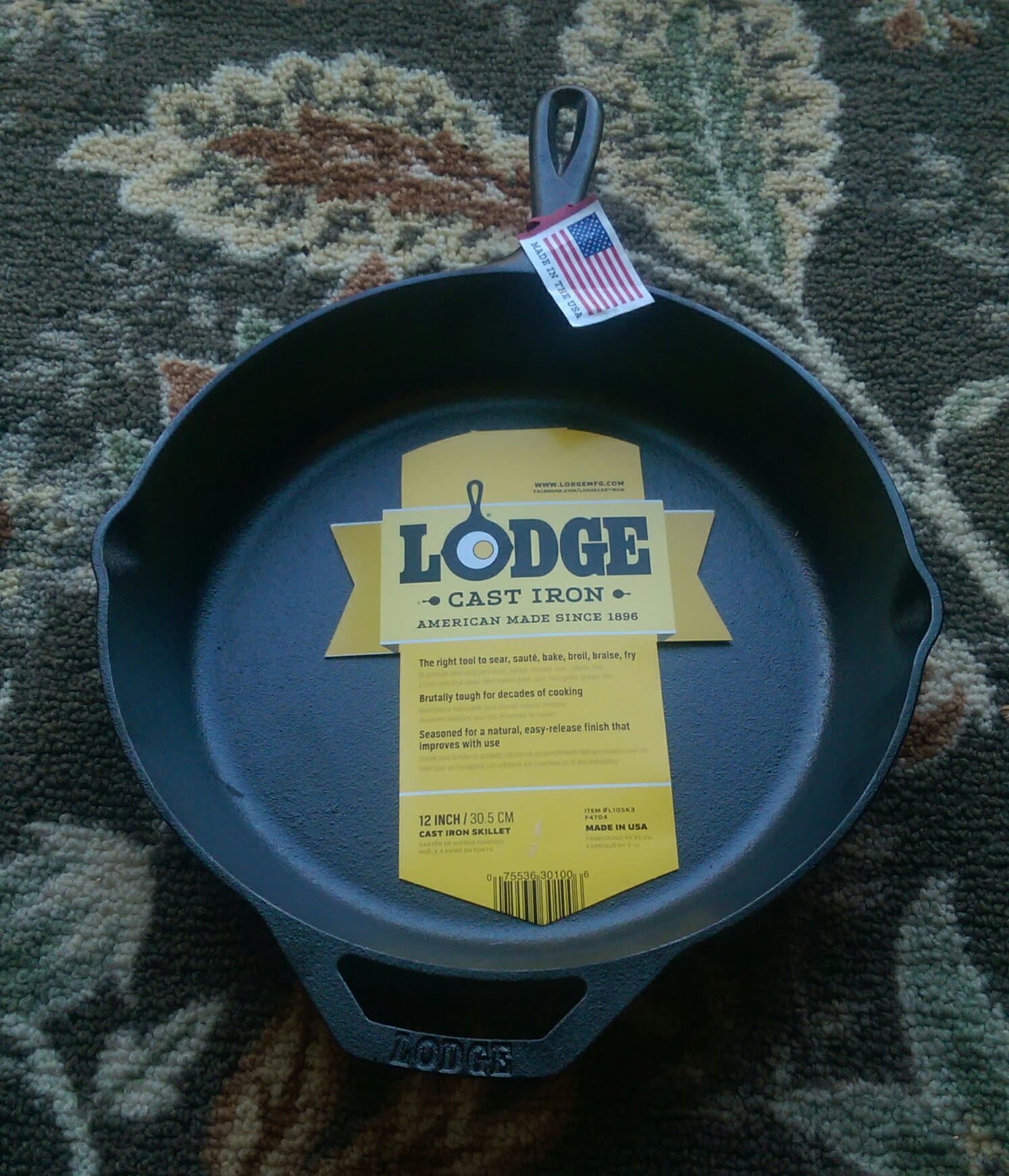 Lodge 12-inch cast-iron skillet viewed from above, showing the seasoned cooking surface, long handle, helper handle, and pour spouts